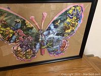 Frontal image of butterfly puzzle showing colorful pattern and framing under glass.