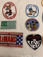 Photo of assorted vintage patches including Speedy Gonzales, Blues a winner, Le Mans racing, and a love scorpion patch.