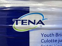 Close-up of TENA logo and product name Youth Briefs on package.