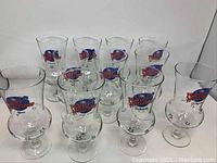 Photo showing all 11 Planet Hollywood hurricane cocktail glasses, clear glass with logo and star details