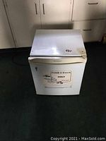 Photo of white Simplicity bar fridge from front showing door handle, sticker, and size.