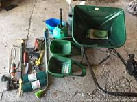 Overview of spreaders, watering cans, garden tools, and accessories on concrete floor