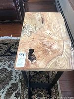 Top view showing wood grain pattern and epoxy fill adjacent to a knot, black metal base visible