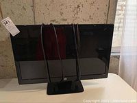 Front view of HP 27-inch monitor on stand with power and video cable draped over.