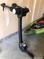 Full view of the hitch-mounted rack standing upright against garage wall with kayak in background