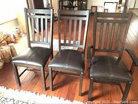 Three chairs (two side chairs and one armchair) front view on hardwood floor