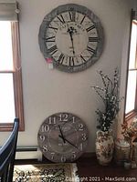 Photo showing both clocks mounted and resting near windows, displaying their size and style.