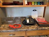 Wide view showing all items on countertop including cutting boards, bakeware, Pyrex pie pan with protector and inserts.