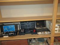 Four tool sets arranged on a wooden shelf, including socket sets and screwdriver bit cases.