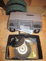 Gray plastic Dremel carrying case closed on wooden surface