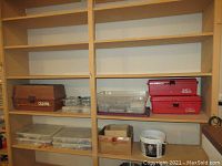 Shelf with various tool boxes and plastic containers with hardware items