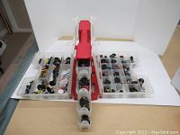 Overhead view of the open plastic carrying case containing numerous HeroClix figurines arranged in multiple compartments for organized storage.