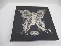 Collector's box displaying butterfly made of handprints design on black background with Bioshock 2 branding.