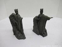 Pair of resin bookends depicting two regal crowned figures with swords on rocky bases.