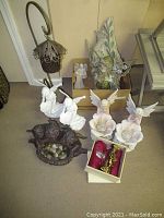 Overview of lot showing angel and fairy figurines, flower fairy statues, cherub garden decor, hanging lantern, and wooden box with figurines.