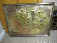 Full view of framed metallic gold colored Lord of the Rings Middle Earth map showing detailed geography.