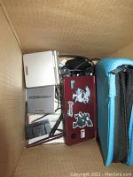 Box with four handheld consoles, cables, stylus and carrying case