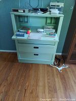 Front view of the light green wooden drop front secretary desk showing open writing surface with compartments and drawers below