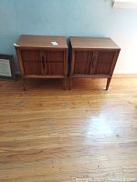 Two identical wooden Thomasville end tables side by side on hardwood floor