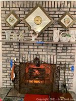 Full view of shelf above fireplace showing various vases and candlesticks.