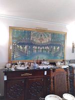 Full view of the large wall art above a sideboard with various collectibles, showing the ballroom scene in blue and green tones and the gold frame.