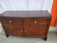 Front view of cherry solid wood sideboard showing two drawers above two cabinet doors with starburst wood pattern and satin nickel knobs.