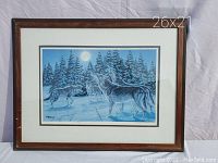 Full view of R. DeWolfe framed print depicting wolves in a snowy moonlit forest with walnut wood frame measuring 26" x 21".