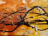 Close-up showing textured raised embellishments on orange and yellow abstract canvas with black linear strokes.