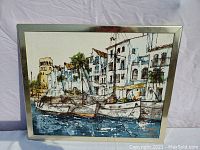 Front view of Bernard Dufour print framed in polished silver frame, showing harbor scene with boats and white buildings