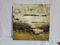 Front view of the square abstract canvas displaying warm neutral tones with black splashes and thick brush texture.