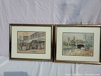 Two framed and matted prints by Inge Claussen depicting Montreal outdoor market and Parliament Buildings scenes, displayed side by side.