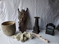 Photo showing full lot including planter, tree face, cherub statue, tall candle holder, metal lantern candle holder, garden spade.