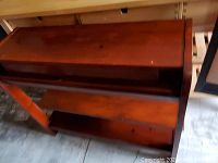 Top-down angle of console table showing drawer closed and curved side panel with circular cutouts.