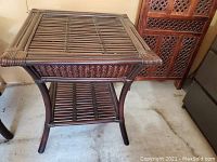 Front view of side table showing slatted top surface and lower shelf