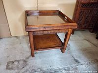 Front and side view of the wooden side table with glass inlay tray top and lower shelf, showing the overall design and finish.