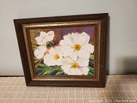 Frontal image of the framed floral painting showing white peonies on a brownish-purple background with a dark brown wooden frame with gold inlay.