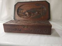Angled view of carved Quebec wall plaque in background and chip carved wooden box in front.