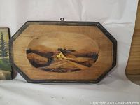 Three wooden Quebec wall plaques arranged side by side showing hand-painted village and nature scenes.