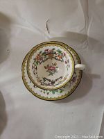 Top view of an Aynsley cup and saucer with floral pattern and gold trim