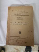 Photo of 'Totem Poles of the Gitksan, Upper Skeena River, British Columbia' book with visible wear and spots on cover.