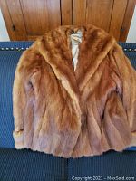 Front view of vintage reddish-brown mink fur jacket with wide collar, showing plush dense fur.