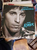 Photo of a stack of vinyl albums with Bruce Springsteen's The River album cover visible on top.
