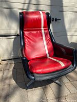 Front angle view showing black shell, red cushions with white stripe