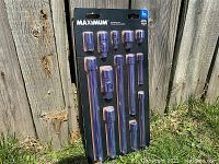 Full view of unopened socket accessory set with all pieces visible in blister packaging against wooden fence background.