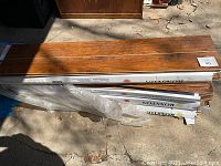 Stacked boxes of Roxston laminate flooring with some loose boards on top, showing wood-tone finish.