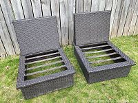 Two brown resin wicker patio chair frames with backrests seen from an angle showing the metal support bars on the seat area.