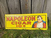 Full view of yellow rectangular metal advertising sign with 'Napoleon Cigar 10¢' text and Napoleon portrait.
