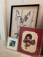 Full view of all three framed Asian art pieces grouped on floor showing sizes and details