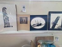 Shelf with pen and ink sketches including totem pole, ship, eagle, and landscape