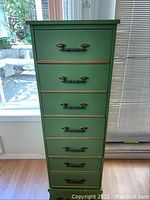 Front view of the painted green seven drawer tallboy chest showing drawer handles and finish.